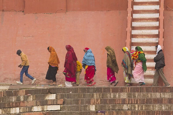 India, Uttar Pradesh, Varanasi. women and child walk along the Ganges river bulkhead