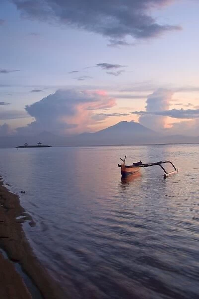 Indonesia, Bali. Sunrise on fishing boat and Sanur Beach with Mount Gunung Agung in distance