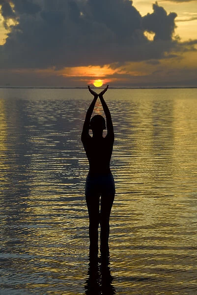 Indonesia, Bali. Woman silhouetted at sunrise on Sanur Beach. Credit as: Jones-Shimlock