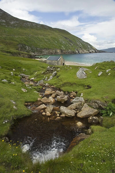 Ireland, Achill Island. A stream runs down to the turquoise waters of Keem Bay past