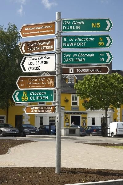 Ireland, County Mayo, Westport. One post holds distance and directional signs in English and Gaelic