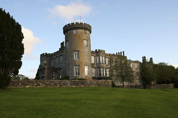 In Ireland, the Dromoland Castle turret grounds and green lawn with blue sky white clouds