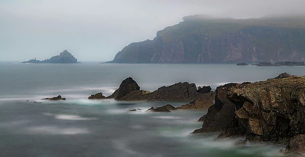 Ireland, Ferriter's Cove. Ocean and cliff in misty landscape