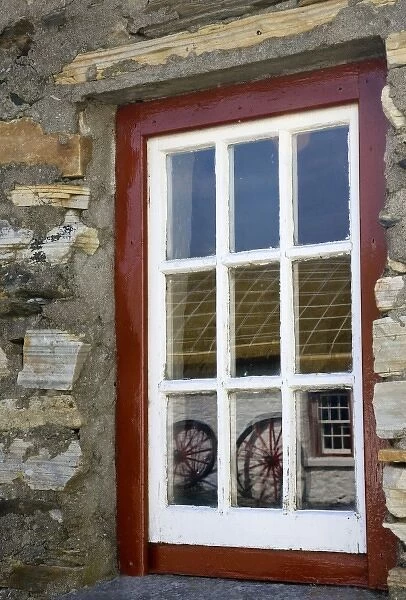 Ireland, Gleann Cholm Chille. Reflection of wagon wheels in a red- trimmed window