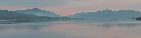 Ireland, Portmagee Bay. Panoramic of sunrise on ocean and mountains