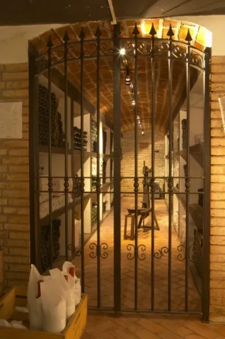 Framed Print : An iron gate leading in to the private wine cellar with aging bottles. Bodega Pisano Winery Framed Print : An iron gate leading in to the private wine cellar with aging bottles. Bodega Pisano Winery