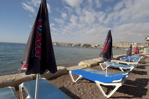 Israel, Eilat, beach lounge chairs and umbrellas along the sea at this popular resort