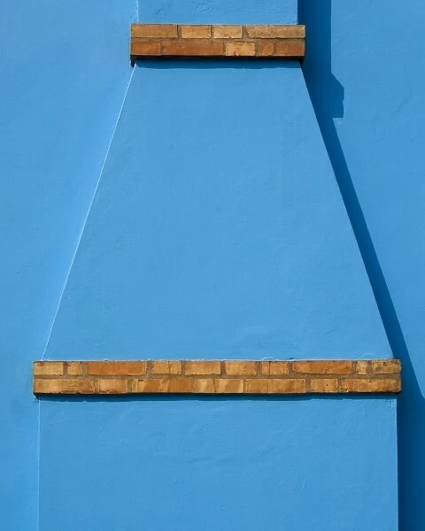 Italy, Burano. Blue stucco exterior of chimney and colored brick