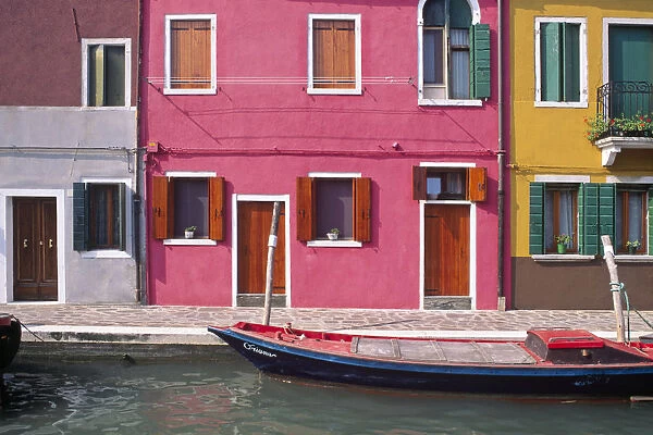 Italy, Burano. Colorful house exteriors and boat in canal