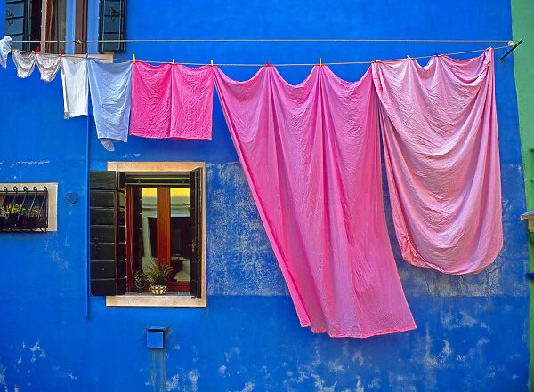 Italy, Burano. Drying laundry and colorful window and wall