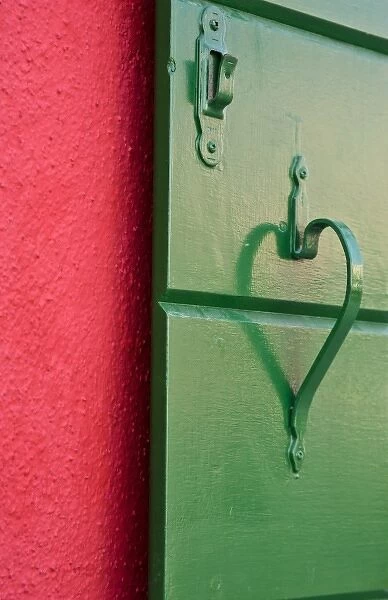 Italy, Burano. Handle on green shutter contrasts with red wall