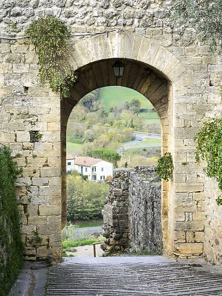 Italy, Chianti, Monteriggioni. Looking out an arched entrance into the walled town
