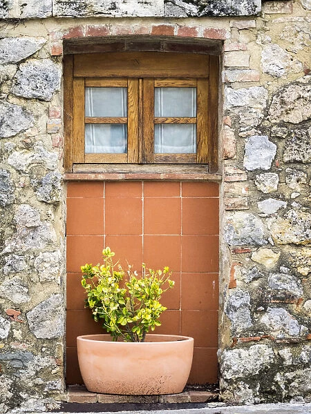 Italy, Chianti, Monteriggioni. Wooden shutters on a window with planter below