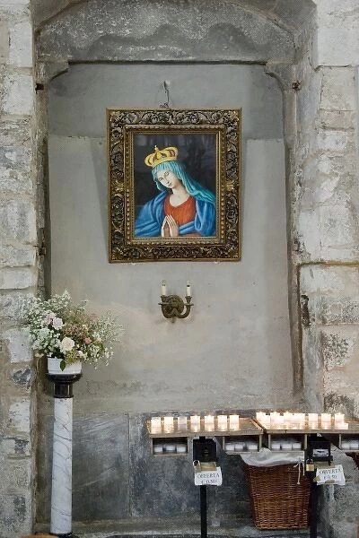 Italy, Cinque Terre, Manarola. A niche with candle offerings under a picture of Virgin Mary