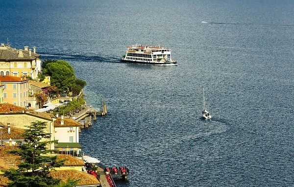 Italy, Lake Garda. A ferry arrives at the lake village of Limone