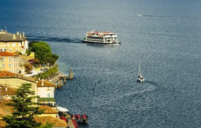 Framed Print : Italy, Lake Garda. A ferry arrives at the lake village of Limone