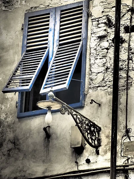 Italy, Pisa. Double windows and lamp on old building