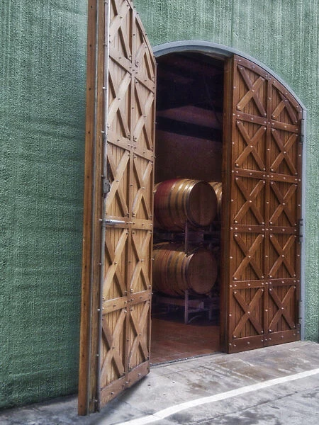 Italy, Tuscany. Beautiful wooden doors leading to a barrel room at a winery