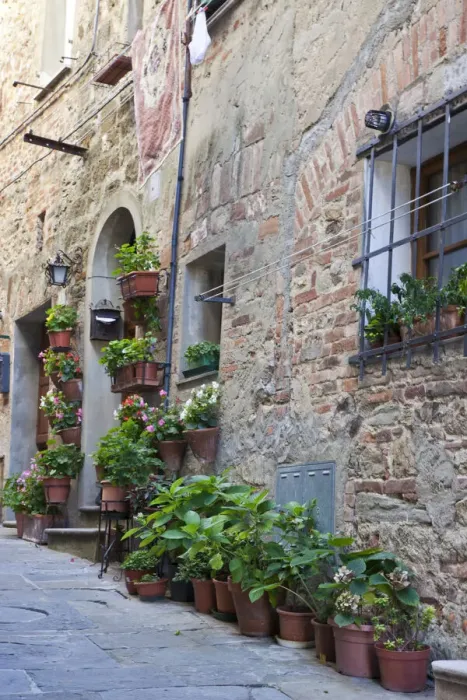 Framed Print : Italy, Tuscany, Crete Senesi, Asciano. Street scene with potted flowers near the entrance of a home in the hill town of Asciano