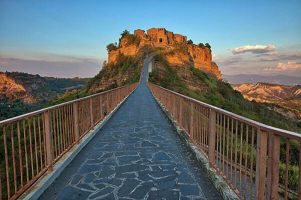 Italy, Tuscany. Evening light of Civita di Bagnoregio and the long bridge leading to town