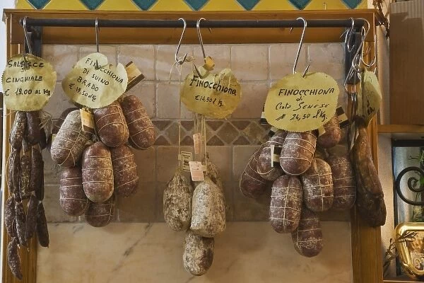 Italy, Tuscany, Pienza. Assortment of meats hanging in a store