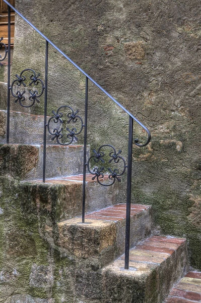 Italy, Tuscany, Pienza. Steps with wrought iron railing leading to the entrance to a home in Pienza