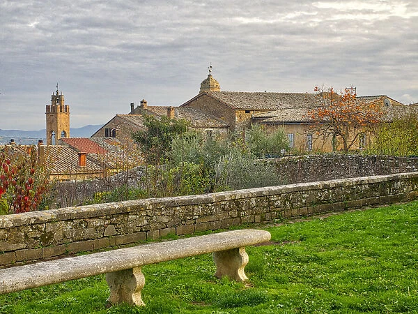 Italy, Tuscany, Province of Siena, Montalcino. Stone bench overlooking the town of Montalcino