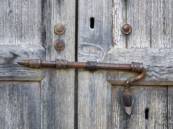 Italy, Tuscany. Unique metal door lock on an old wooden door