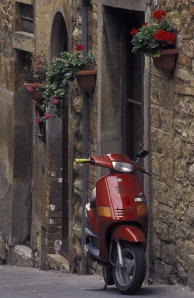 Italy, Tuscany, Volterra Geraniums and motorcycle on narrow street