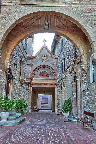 Italy, Umbria, Assisi. Archway and path leading to the Monastero della Santa Croce Catholic Church