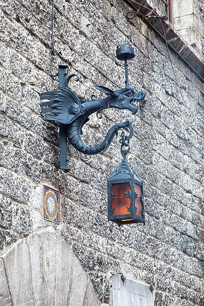 Italy, Umbria, Assisi. Old stone wall with Dragon Lantern