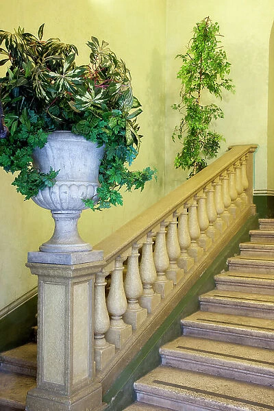 Italy, Umbria, Spoleto. Concrete urn filled with greenery on the end of a banister of a staircase