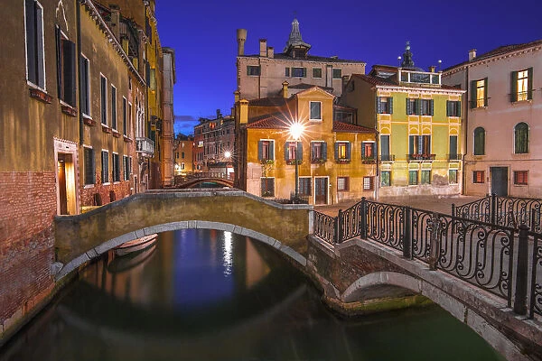 Italy, Venice. Canal bridge and buildings at night