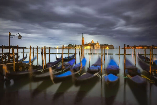 Italy, Venice. Moored gondolas and Church of San Giorgio Maggiore at sunrise. Credit as