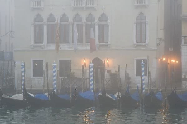 Italy, Venice. A row of gondolas seen through the fog on the Grand Canal