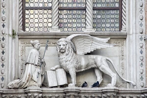 Italy, Venice. Statue of a winged lion and the Doge on the Doges Palace