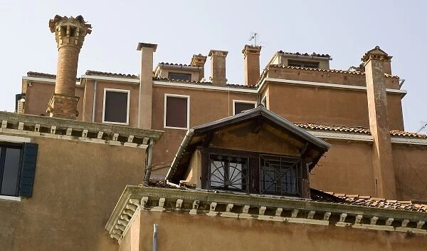 Italy, Venice. Tiled roofs, chimneys and windows of a colorful building