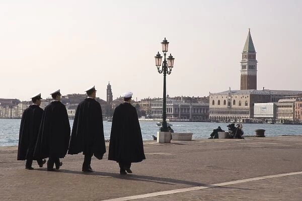 Italy, Venice. Four uniformed Navy men walking along the Riva degli Schiavoni promenade