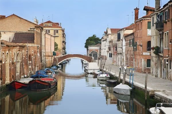 Italy, Venice. View of boats and homes along one of the many city canals. Credit as