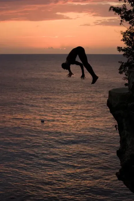 Framed Print : Jamaica, Negril, Silhouette of young man leaping from from cliff above Pirates Cave Framed Print : Jamaica, Negril, Silhouette of young man leaping from from cliff above Pirates Cave