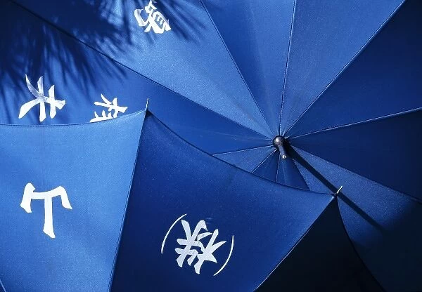 Japan, Hiroshima Pref. Miyajima Island. Blue umbrellas dry in the bright sun on Miyajima Island