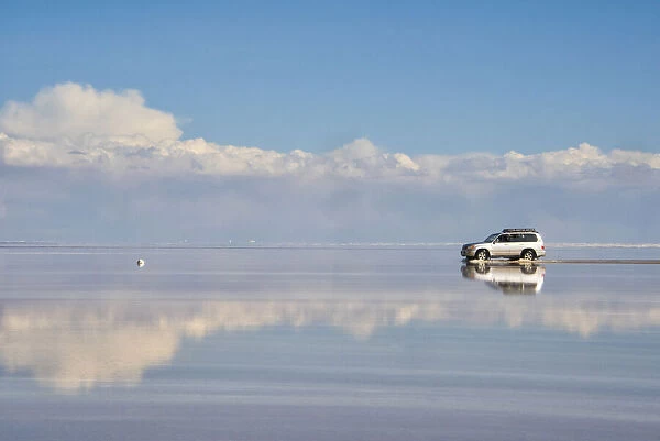 Jeep driving on the reflected surface of the salt flat, Salar de Uyuni, Potosi Department