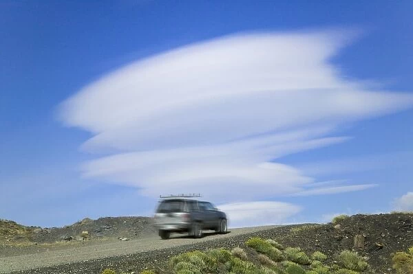 A jeep on the road in the mountain, dramatic clouds in the blue sky, Torres del Paine National Park