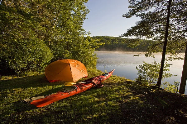 A kayak and a tent next to the Androscoggin River at a remote campsite at Mollidgewock