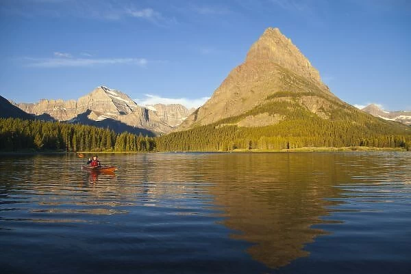 Kayaking in Swiftcurrent Lake at sunrise in the Many Glacier Valley of Glacier National Park
