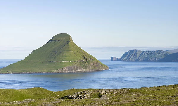 Koltur island at sunrise, the island Vagar in the background The island Streymoy