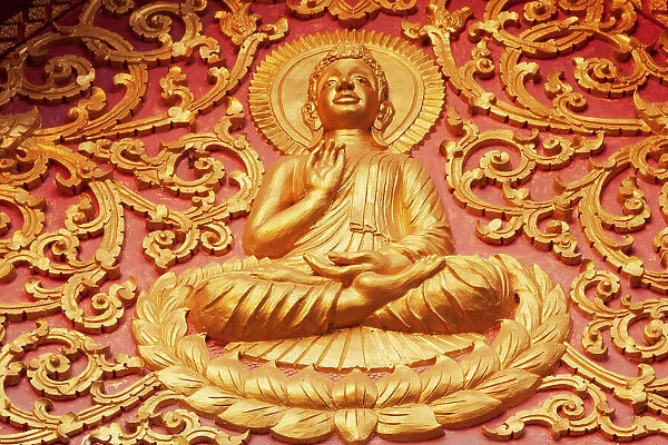 Laos, Luang Prabang. Golden relief carving of Buddha