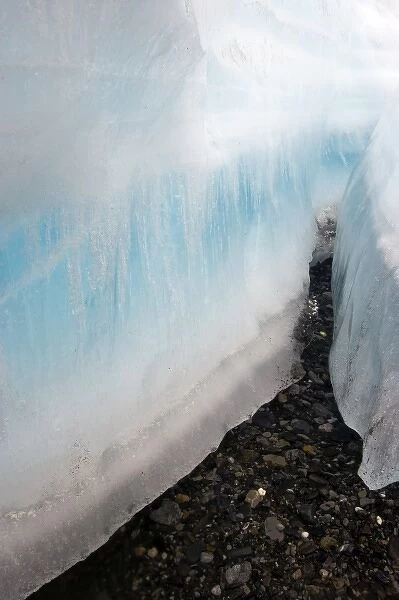 A large crevice in the arctic aufeis revealing laminations of ice above the dark