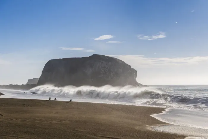 Framed Print : Large haystack rock with crashing waves and birds on the beach in California Framed Print : Large haystack rock with crashing waves and birds on the beach in California