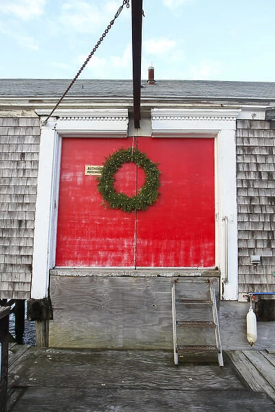 A large wreath adorns red doors on a building at Barnstable Harbor, Barnstable, Cape Cod